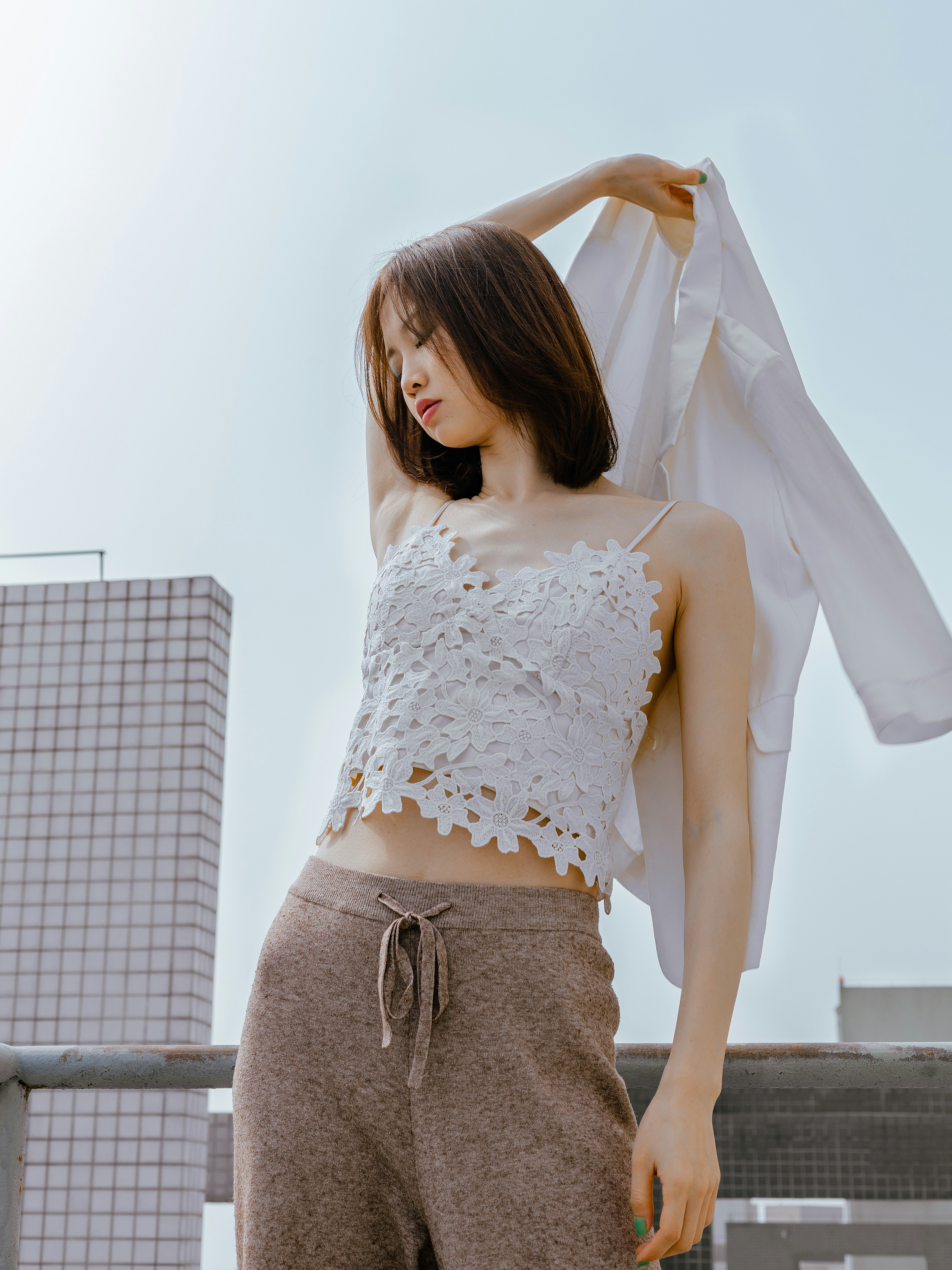 woman in white lace dress standing near white wall